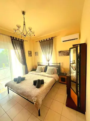 a bedroom with a large bed with a chandelier at Niki's House in Haraki