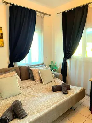 a bed with two pairs of slippers on top of it at Niki's House in Haraki