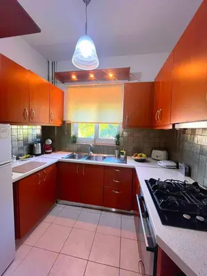 a kitchen with orange cabinets and a sink and a stove at Niki's House in Haraki