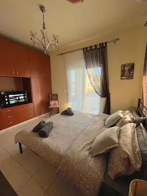 a bedroom with a large bed and a window at Niki's House in Haraki