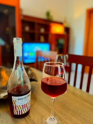 a bottle of wine and a glass on a table at Niki's House in Haraki