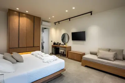 a bedroom with a bed and a tv and a couch at Monarco Executive Rooms in Rhodes Town
