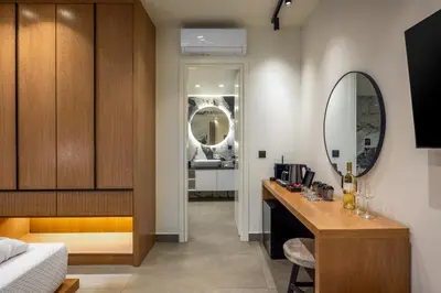 a bedroom with a desk and a mirror and a bed at Monarco Executive Rooms in Rhodes Town