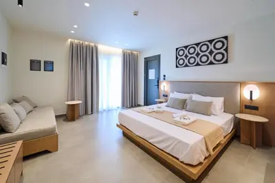 a bedroom with a large bed and a couch at Monarco Executive Rooms in Rhodes Town