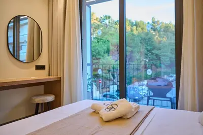 a bedroom with a bed with a view of a balcony at Monarco Executive Rooms in Rhodes Town