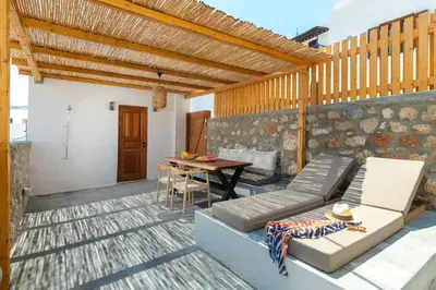 a patio with a couch and a wooden table at Tapanis luxury house in Líndos