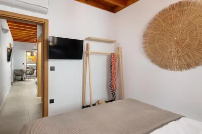 a bedroom with a bed and a flat screen tv on the wall at Tapanis luxury house in Líndos