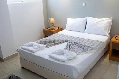 a bedroom with a bed with white sheets and pillows at Ismini Basement Retreat in vlicha