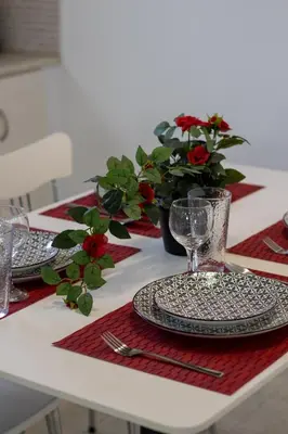 a table with plates and glasses on a red napkin at Ismini Basement Retreat in vlicha