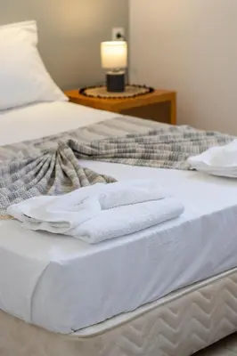 a bed with two towels sitting on top of it at Ismini Basement Retreat in vlicha