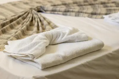 a white towel sitting on top of a bed at Ismini Basement Retreat in vlicha