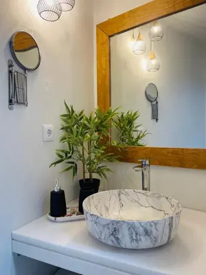 a bathroom with a marble sink and a mirror at Serenity Luxury Apartment in Symi