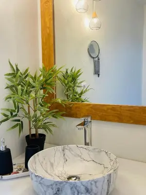 a bathroom with a marble sink and a mirror at Serenity Luxury Apartment in Symi