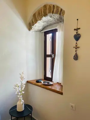 a window in a room with a table and a vase at Serenity Luxury Apartment in Symi