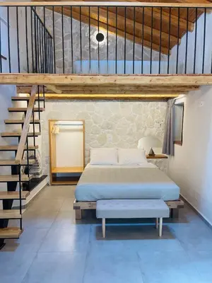 a bedroom with a bed and a staircase at Serenity Luxury Apartment in Symi