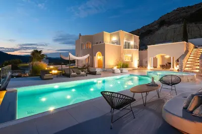 a villa with a swimming pool at night at Ralu Villa - Faliraki & Traganou Beach in Kalithies
