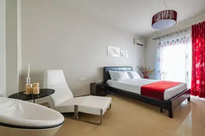 a bedroom with a bed and a table and a chair at Mira Villa - Faliraki & Traganou Beach in Kalithies