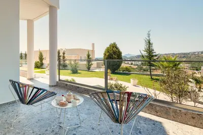 a patio with a table and chairs and a view at Mira Villa - Faliraki & Traganou Beach in Kalithies