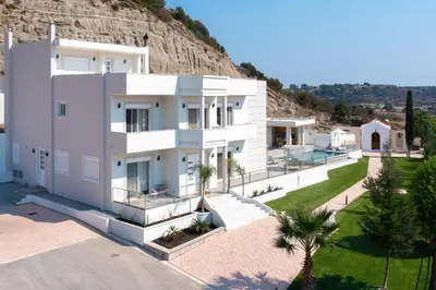 a white house with a hill in the background at Mira Villa - Faliraki & Traganou Beach in Kalithies