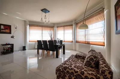 a living room with a couch and a table with chairs at Mira Villa - Faliraki & Traganou Beach in Kalithies