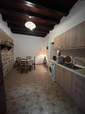 a kitchen with a table and a washing machine at Zoe House-Old Town in Rhodes Town