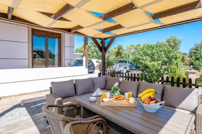 a table with a tray of fruit on a patio at Thalpori Villa in Pastida