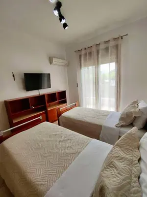 a hotel room with two beds and a flat screen tv at Thalpori Villa in Pastida