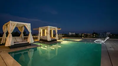 a swimming pool with two chairs and a gazebo at Grand Aqua Luxury Villa by Mintzi in Yennadhion