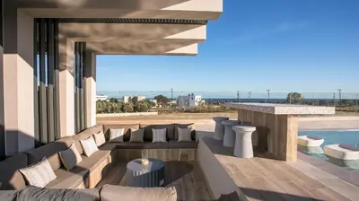 a living room with a couch and a swimming pool at Grand Aqua Luxury Villa by Mintzi in Yennadhion