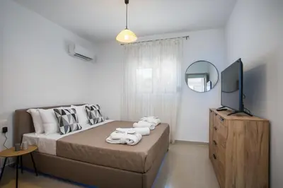a bedroom with a bed and a flat screen tv at Zafora Apartment in Koskinou