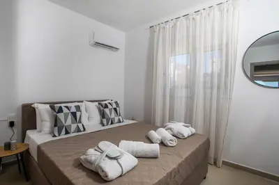 a bedroom with a bed with towels on it at Zafora Apartment in Koskinou