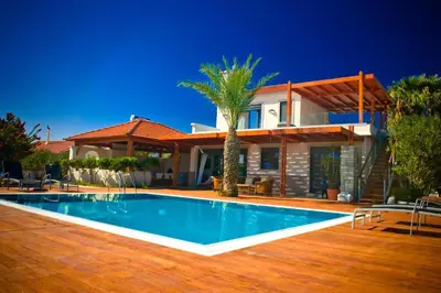 a villa with a swimming pool in front of a house at Villa Fenia in Gennadi