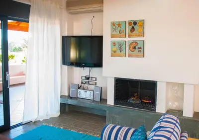 a living room with a fireplace and a flat screen tv at Villa Fenia in Gennadi