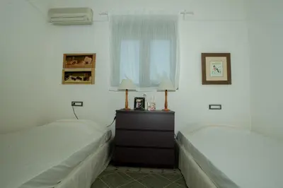 two beds in a bedroom with white walls at Villa Fenia in Gennadi