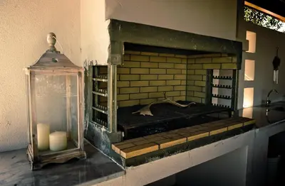 a brick fireplace with two candles and a glass jar at Villa Fenia in Gennadi