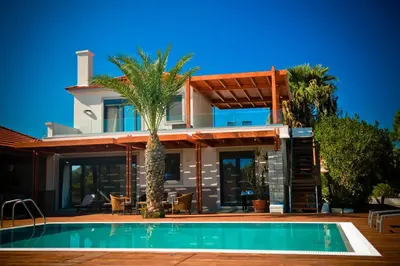 a house with a swimming pool in front of it at Villa Fenia in Gennadi