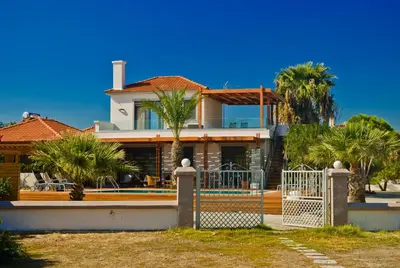 a house with a gate and palm trees at Villa Fenia in Gennadi