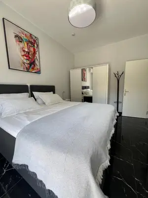 a bedroom with a large white bed with a painting on the wall at Kyra Maria in Rhodes Town