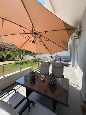 a patio with a table and a large umbrella at Kyra Maria in Rhodes Town