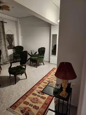 a living room with a table with a lamp and chairs at House ROSI in Rodos city in Rhodes Town