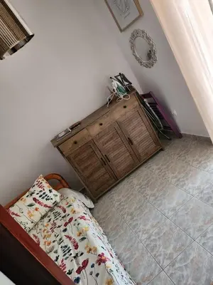 a bedroom with a bed and a wooden dresser at House ROSI in Rodos city in Rhodes Town