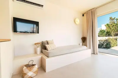 a living room with a couch and a tv on the wall at 3 Villa Complex in Kiotari