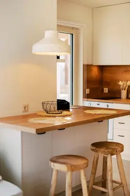 a kitchen with a counter with two wooden stools at 3 Villa Complex in Kiotari
