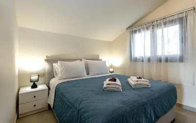a bedroom with a bed with towels on it at Villa Hodaj in Afantou