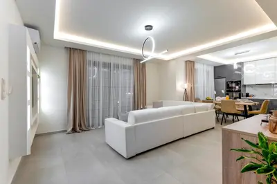 a living room with a white couch and a table at Villa Hodaj in Afantou