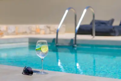 a glass of wine sitting next to a swimming pool at Villa Lambis Harmonia in Líndos