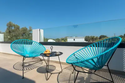 two blue chairs and a table on a balcony at Villa Lambis Harmonia in Líndos