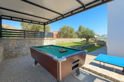 a pool table on a patio with a table at Villa Lambis Harmonia in Líndos