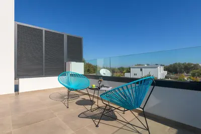 two blue chairs and a table on a balcony at Villa Lambis Athena in Líndos