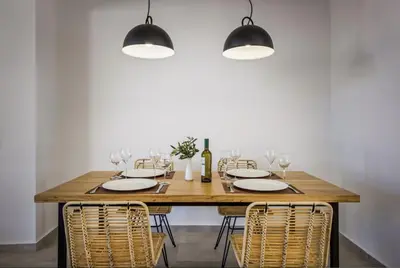 a dining room with a wooden table and chairs at Villa Lambis Athena in Líndos
